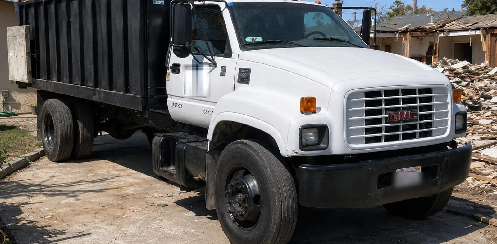 A 101 Hauling Services dump truck loaded on a residential demolition site